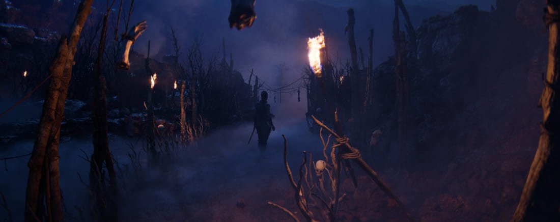 Spooky scene with torchlit path and skeletons in Hellblade 2 video game