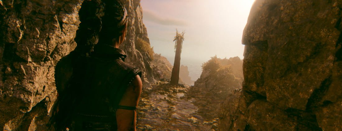 Female warrior on rocky path to distant figure on a cliff in Hellblade 2